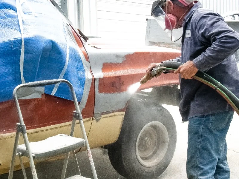 Abrasive paint removal on a vehicle body
