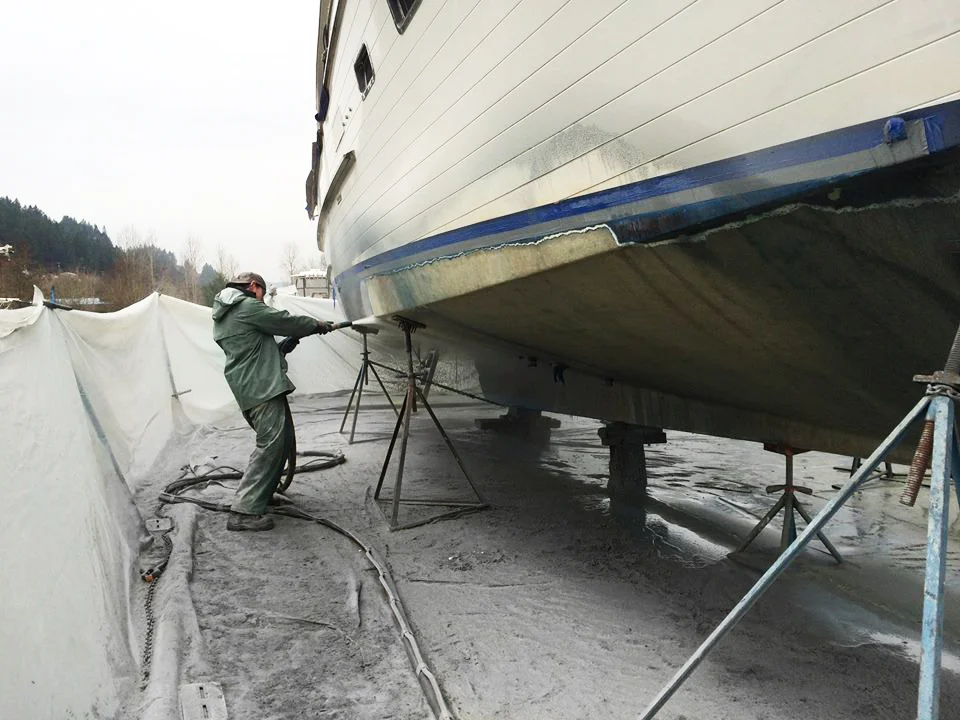Operator preparing a boat hull out of the water