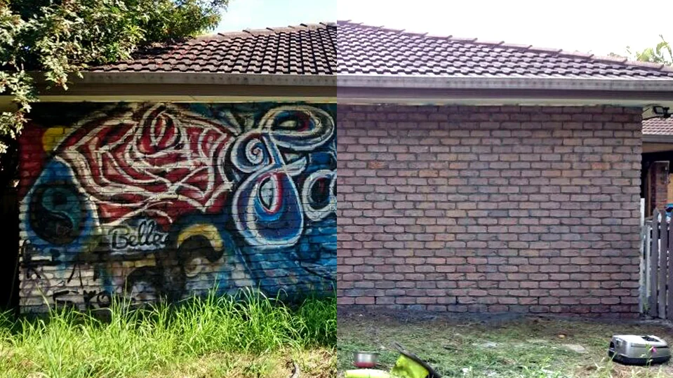 Masonry surface with graffiti and a cleared section